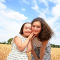 Young girls having fun ln the wheat field